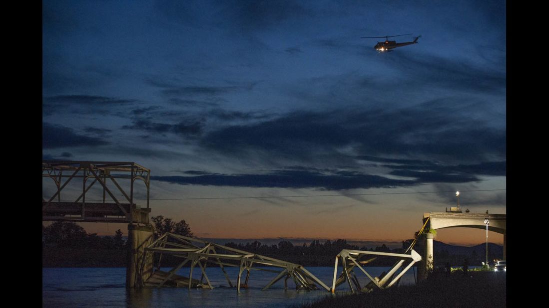 A helicopter leaves the scene as night falls after the collapse on May 23.