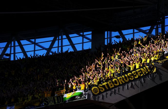 Borussia Dortmund fans in the upper deck of Wembley Stadium cheer for their team.
