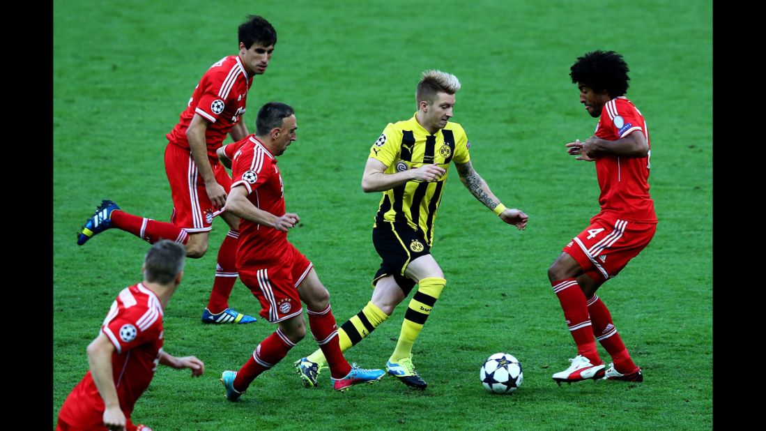 Marco Reus of Borussia Dortmund, center, drives to the goal against Dante, right, of Bayern Munich.
