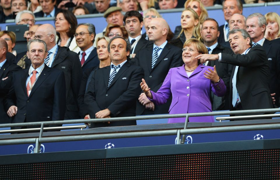 From left, UEFA President Michel Platini, German Chancellor Angela Merkel and German Football Association President Wolfgang Niersbach watch the action from the stands.