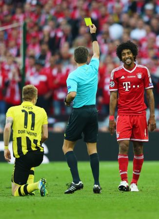 Dante, right, of Bayern Munich is given a yellow card after being called on a foul against a Borussia Dortmund player.