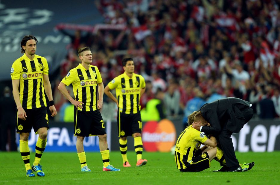 Head Coach Jurgen Klopp, right, of Borussia Dortmund consoles his players after losing to Bayern Munich in the championship match.
