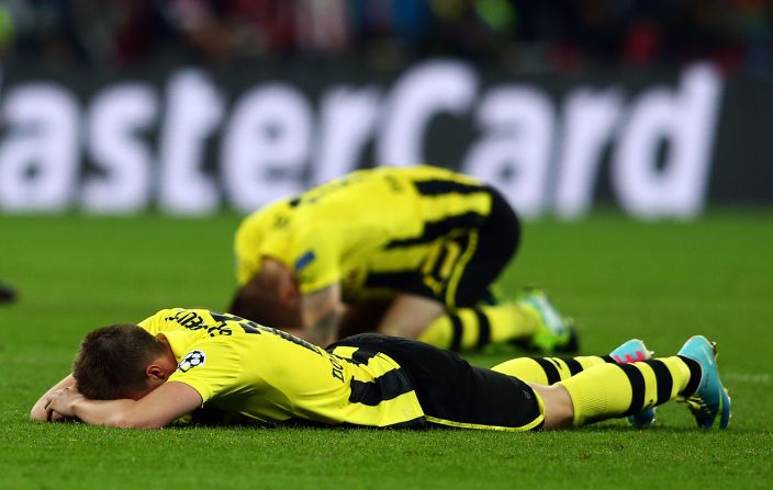 Dortmund players lie on the field in defeat after losing to Bayern 2-1.