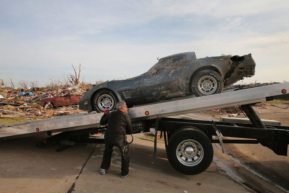 Mike Hitch loads a salvaged Corvette pulled from the rubble onto a tow truck in Moore on May 25.