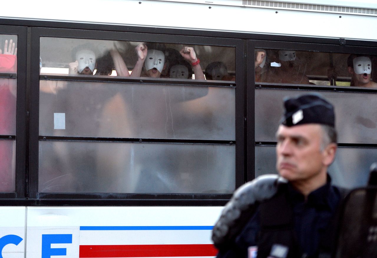 Bare-chested men wearing white masks, members of anti-gay group Hommen, shout slogans as they are detained in a police bus during a demonstration against a bill legalizing same-sex marriages on May 17 in Paris. 