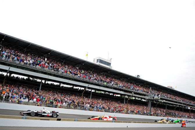 Will Power of Australia in No. 12 leads cars down the front stretch.