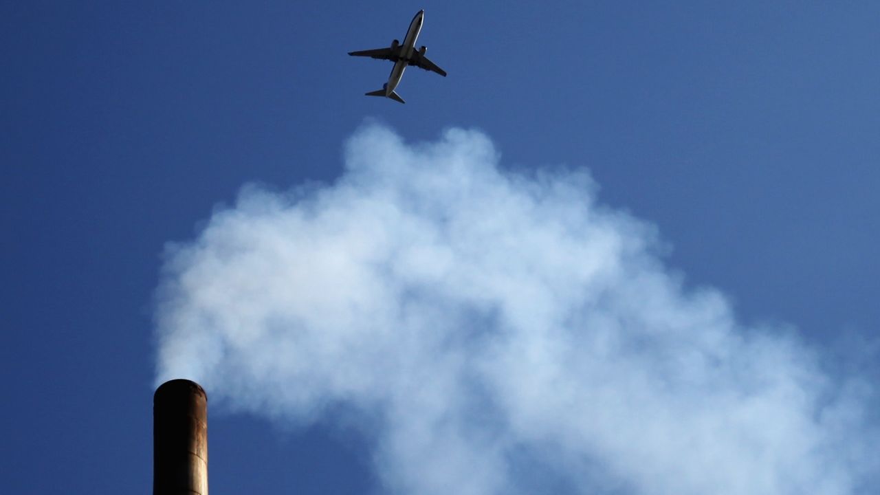 A plane flies over a Beijing chimney in May 2012. China's energy needs are now the highest in the world. 
