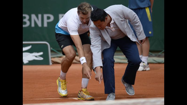 France's Julien Benneteau argues with a referee about a line call during his first round match against Lithuania's Ricardas Berankis on May 27. Benneteau defeated Berankis 7-6(5), 6-3, 5-7, 7-6(5).