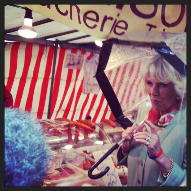 Camilla tastes samples of food at the market. A butcher describes her as "very agreeable, bearing in mind her status."