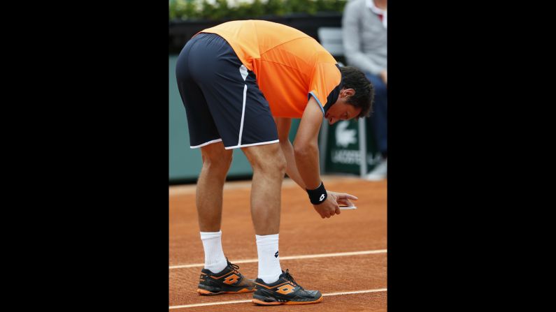 Ukraine's Sergiy Stakhovsky takes a picture with his smartphone on May 27 of a mark on the clay.  Stakhovsky believed the shot to be in, but the chair umpire disagreed. 