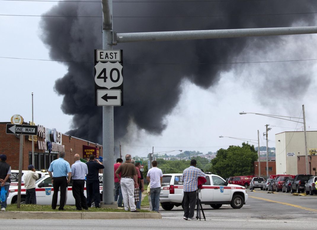 Onlookers stand at a distance as first responders investigate the possibility of toxic chemicals in the explosion.