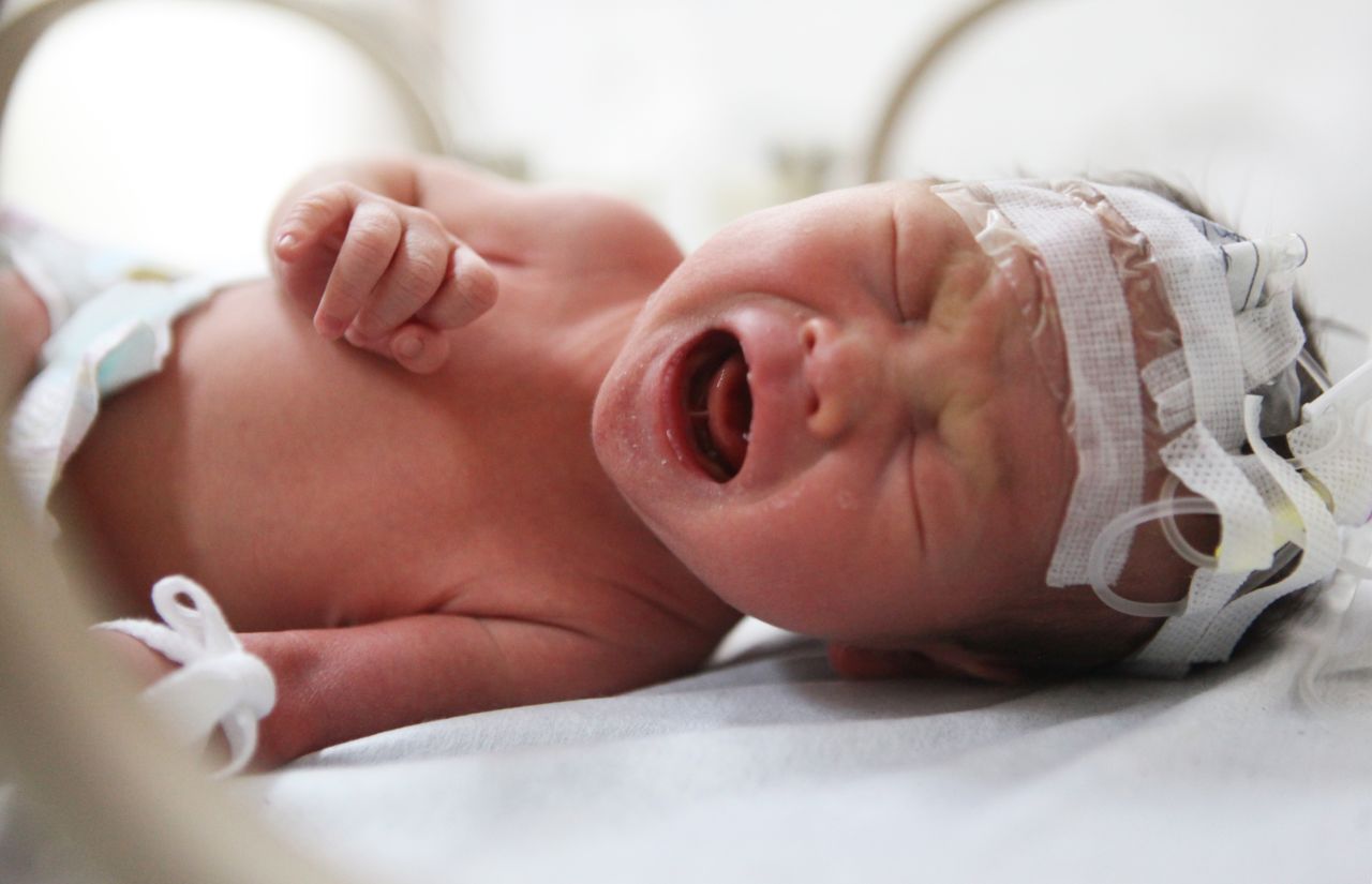 The newborn baby is pictured in the hospital after being rescued.
