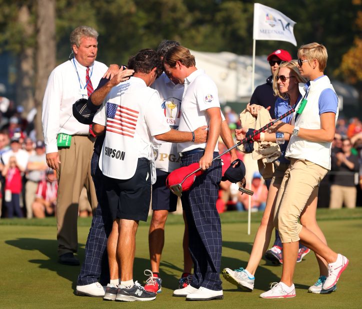 Watson, Webb Simpson and their caddies pray during the 39th Ryder Cup at Medinah, Illinois. They were later met by their wives, who also joined in the huddle.