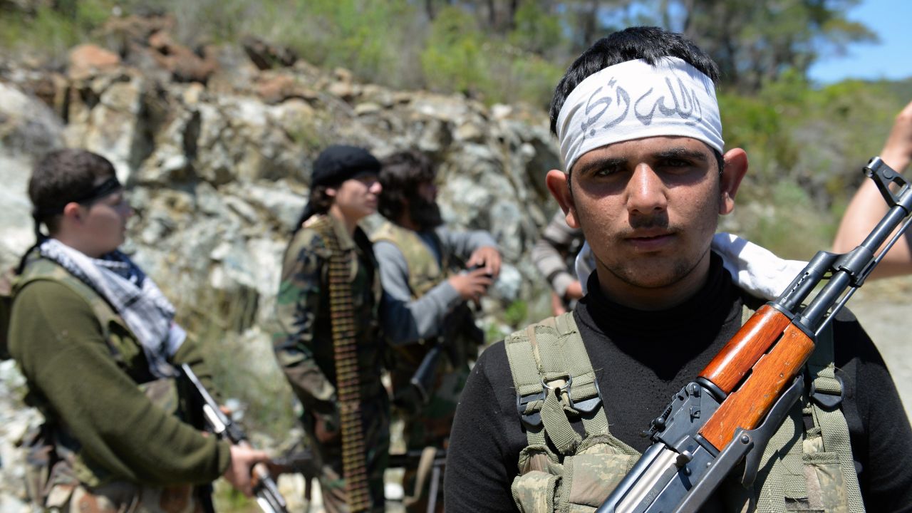 Rebel fighters from the Al-Ezz bin Abdul Salam Brigade train near the al-Turkman mountains in Syria.