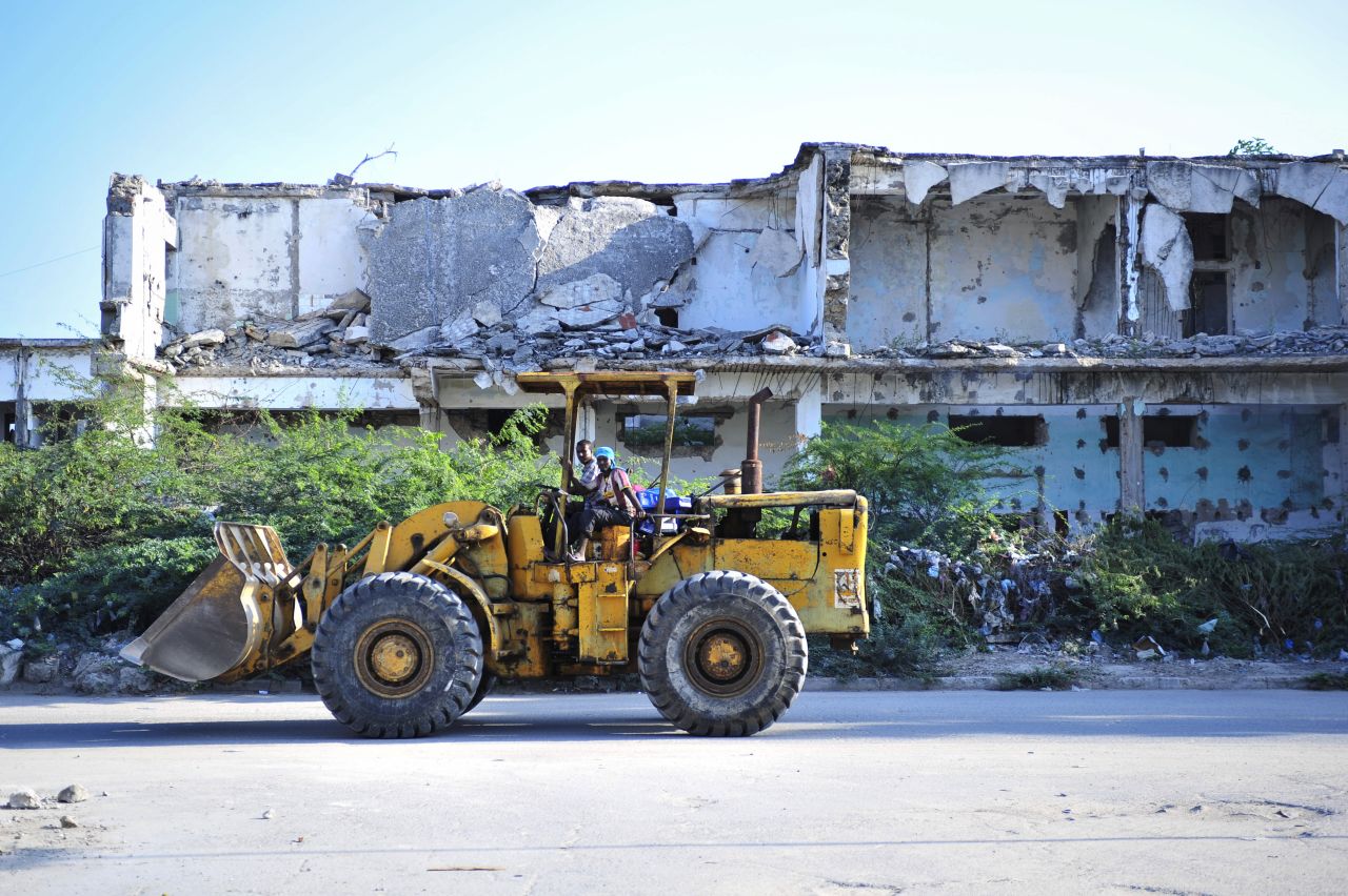 A bulldozer passes in front of a destroyed building in Mogadishu on November 18, 2012. While much of the city has been damaged by conflict, a newfound peace in the city has meant that construction activity has increased.