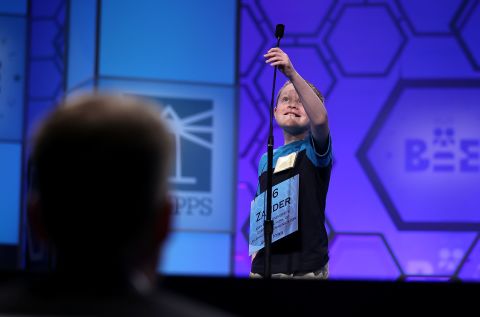  Zander Reed of Ankeny, Iowa, reaches to adjust the microphone before spelling "blottesque" in the third round on May 29. Blottesque means to be painted with blot-like brushwork.  