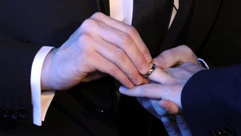 A same-sex couple exchange wedding rings at their marriage ceremony.