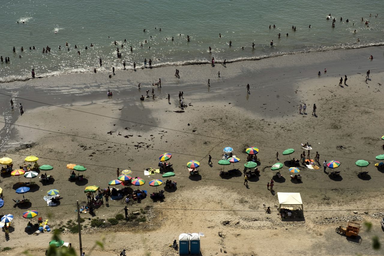 People enjoy a day at the beach of La Costa Verde Bay in Lima.