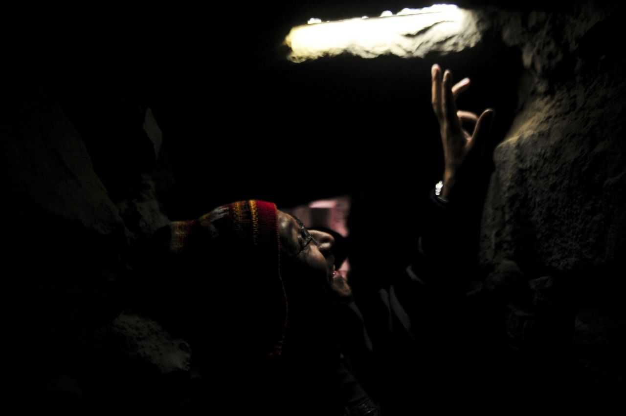 A tourist looks through a hole in one of the underground drainage channels at the Chavin archeology site.