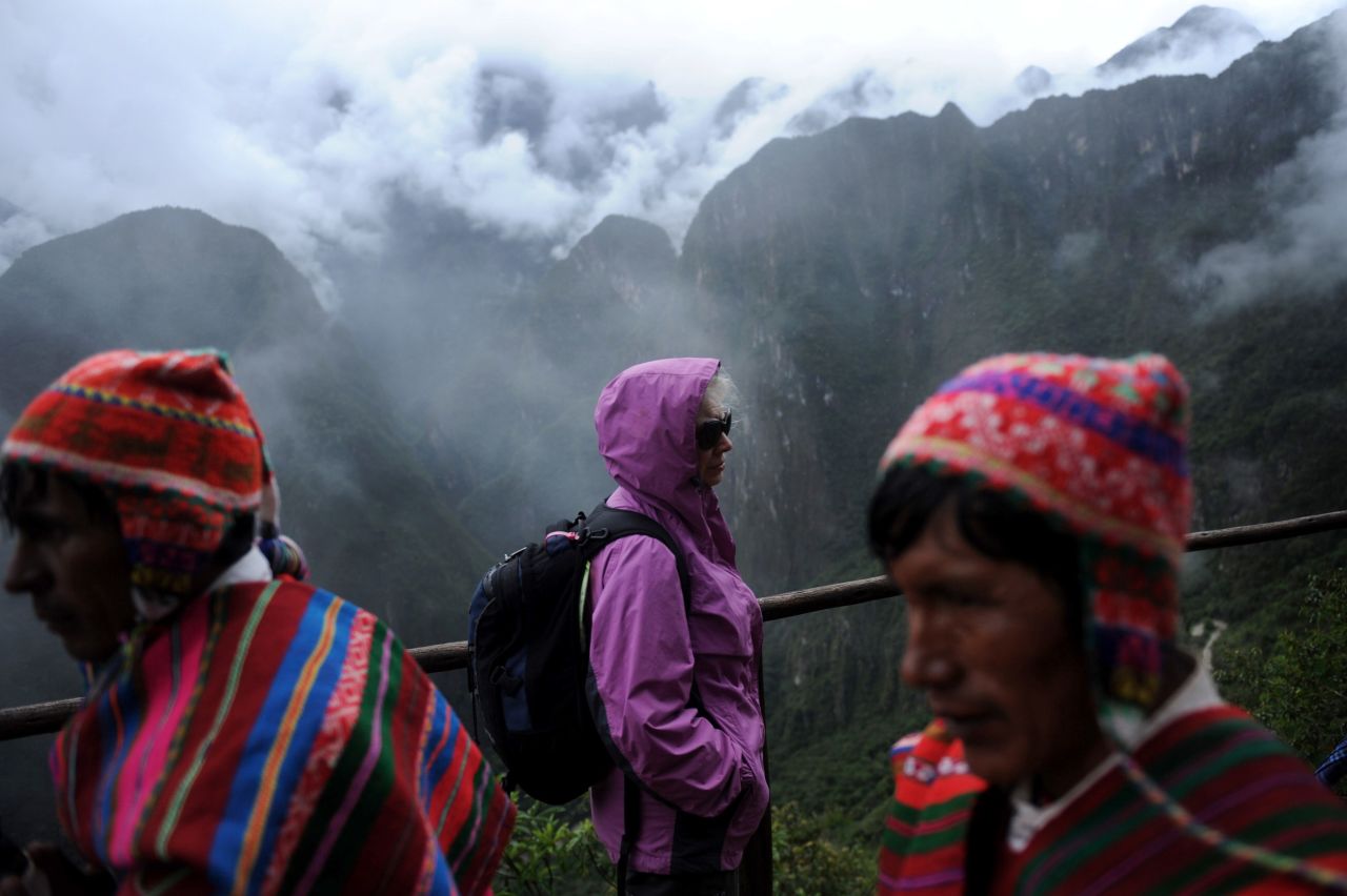 A foreign tourist, center, arrives at Machu Picchu in Cusco.