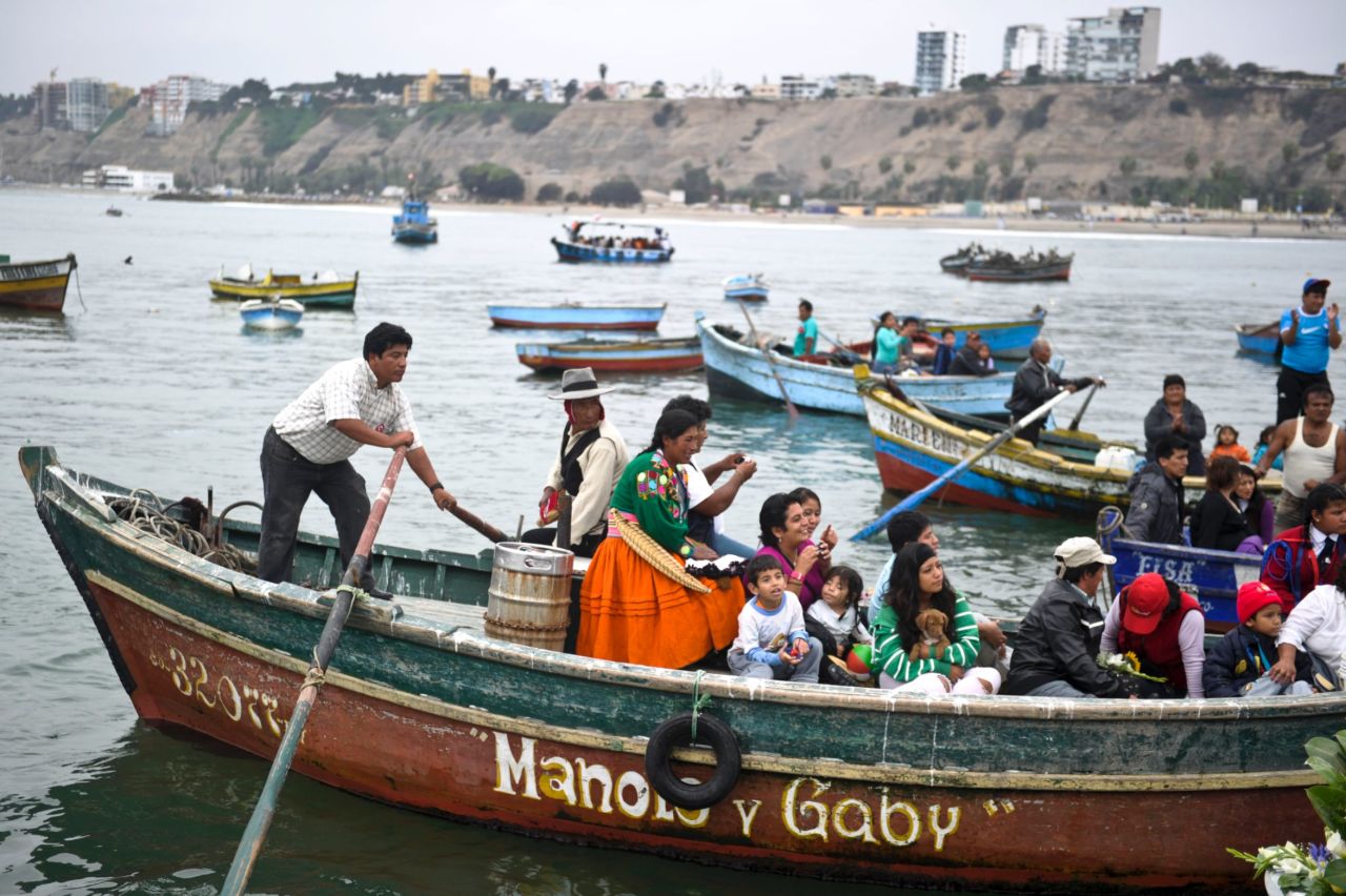 People accompany a maritime procession at the fishing port of Chorrillos in Lima.