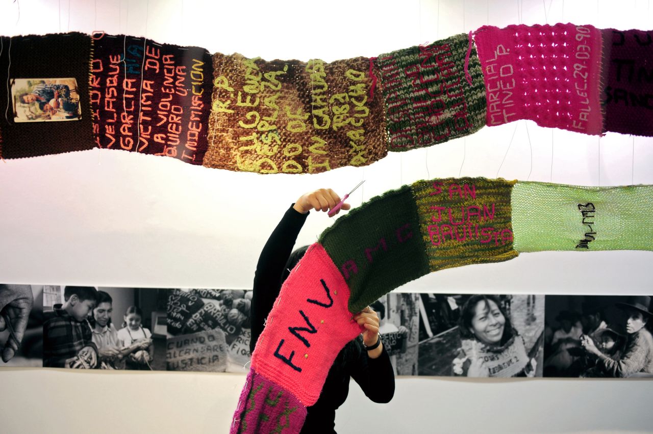 An organizer takes down the "Scarf of Hope" exhibit in Lima on November 29, 2010. The scarf was made by victims of political violence in Peru.
