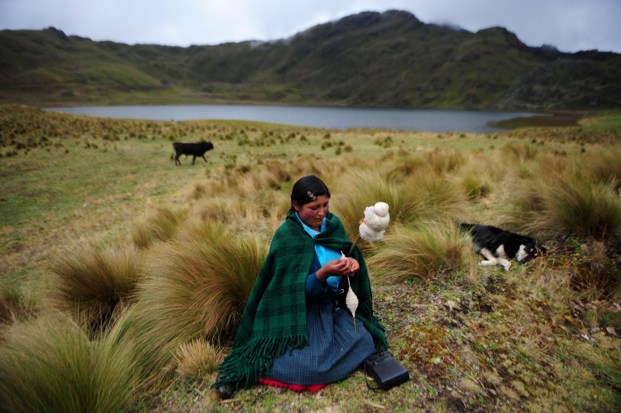 An Andean woman spins wool in front of the Perol lagoon at the Conga mine in Cajamarca.