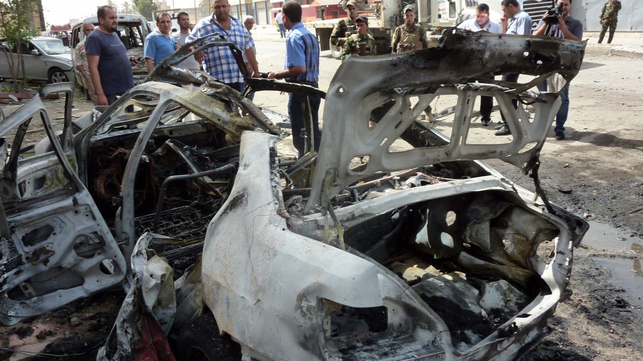 People inspect the site of a blast Thursday in Baghdad, one of many in the recent surge of violence in Iraq.