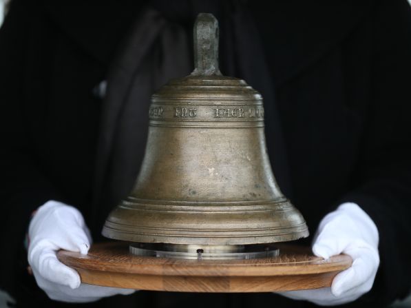 Conservator Susan Bickerton holds the original ship's bell at the location of it's 16th Century sinking.