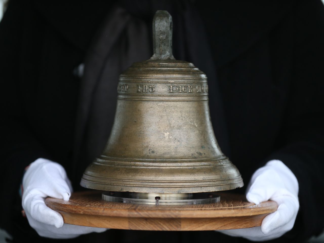 Conservator Susan Bickerton holds the original ship's bell at the location of it's 16th Century sinking.