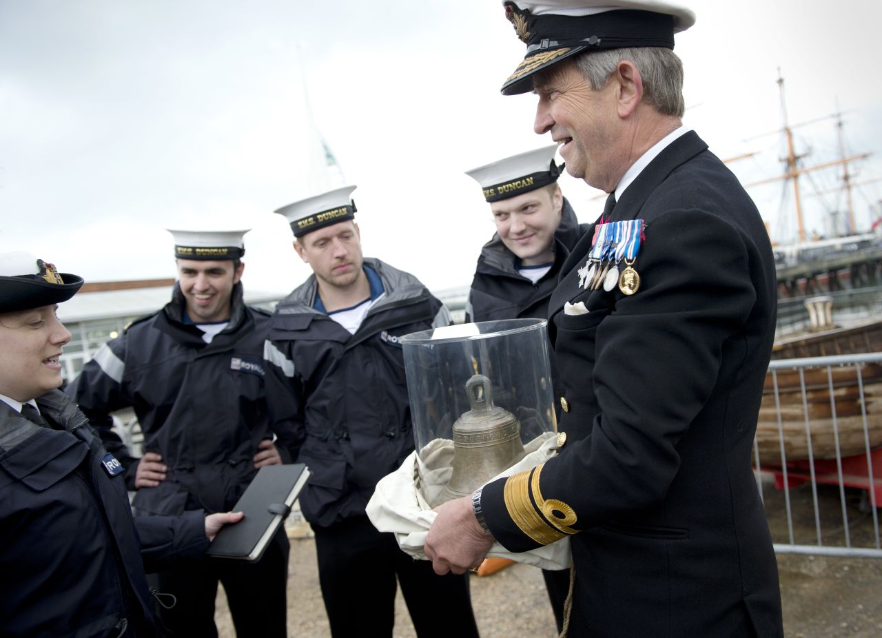 Rear Admiral John Lippiett, right, holds the original bell of the 16th century Tudor warship Mary Rose.