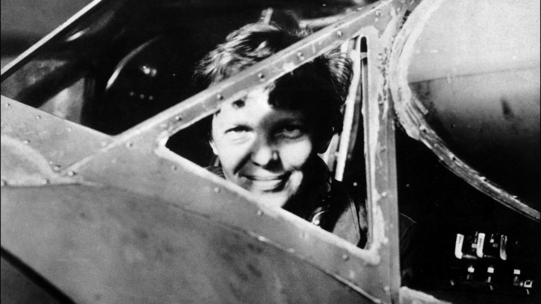 Earhart looks through the cockpit window of her plane.
