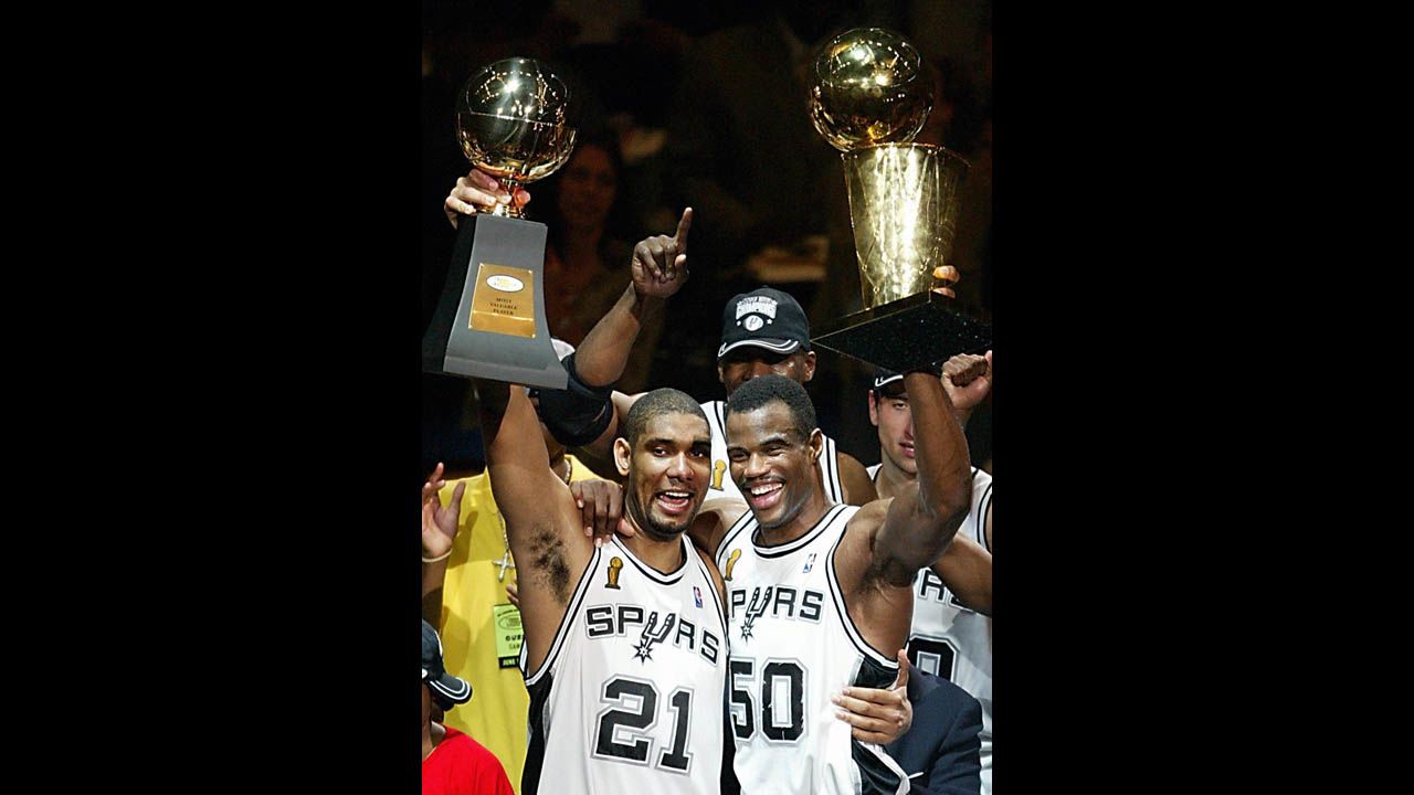 Duncan and David Robinson, aka the Twin Towers, hold up the MVP and championship trophies, respectively, after winning their second championship by toppling the New Jersey Nets in six games in the 2003 NBA Finals.