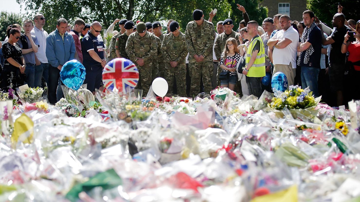 People and soldiers gather Sunday outside the Royal Artillery Barracks, near where British soldier Lee Rigby was killed May 22. 