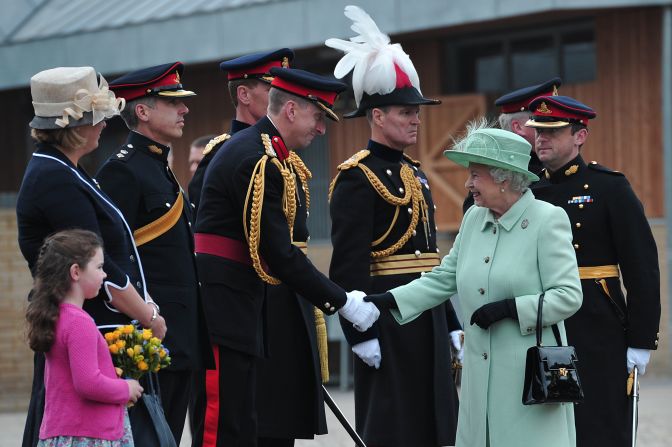 Britain's Queen Elizabeth II is greeted by officers on Friday, May 31, during a visit to the King's Troop Royal Horse Artillery at Woolwich Barracks in London. These barracks housed British soldier Lee Rigby, who worked as a military recruiter as well as a ceremonial drummer. Rigby was killed the week before, a couple of hundred yards from the Royal Artillery Barracks.