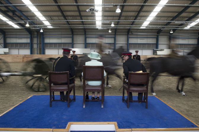 With two soldiers, the queen watches the Gun Display Team as horses run past.