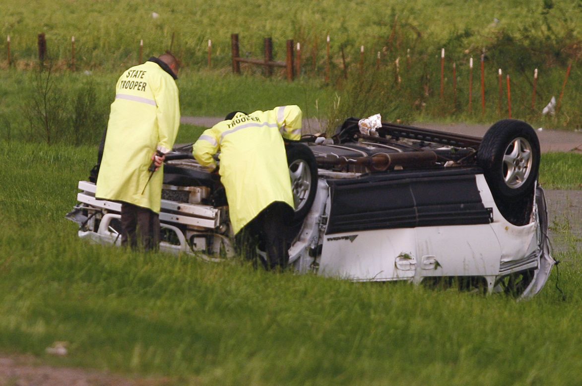 Oklahoma Highway Patrol Troopers inspect an overturned vehicle sitting alongside I-40 near El Reno on May 31.