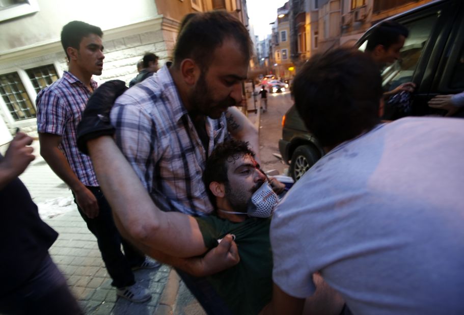 Friends carry an injured protester on May 31. More than a dozen people have been injured in the clashes.