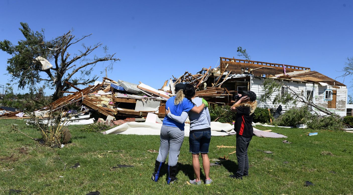 Kim Vanaken, left, consoles her sister Angela Coble, center, along with Amber Kelley while looking at what is left of Coble's house in El Reno on Saturday, June 1. 