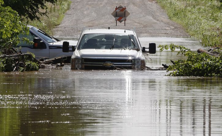Two pickup trucks are pictured stuck in high water along North West 23rd Street in El Reno on June 1. Heavy rain has caused flooding in the area.