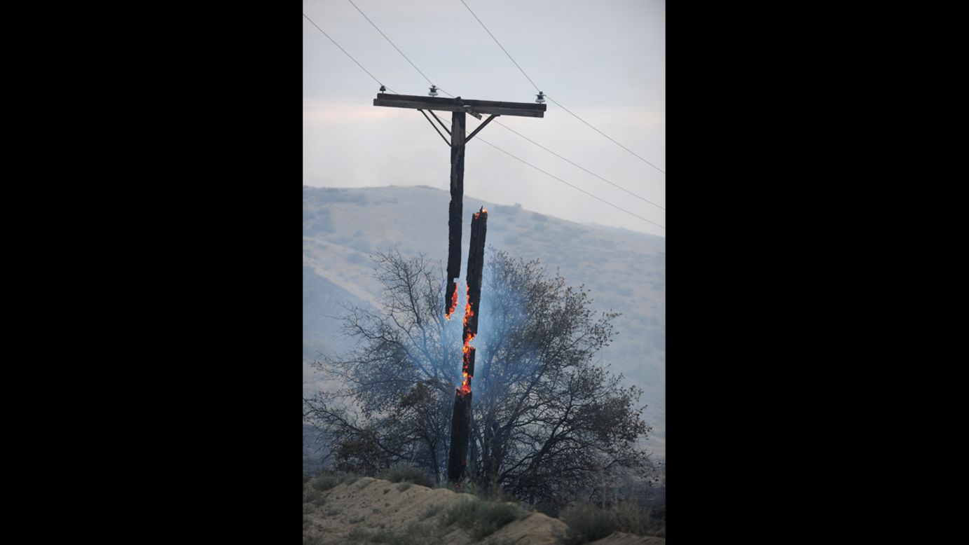 An electrical line pole burns in two pieces after the wildfire ripped through the area overnight in Lake Hughes on June 2.