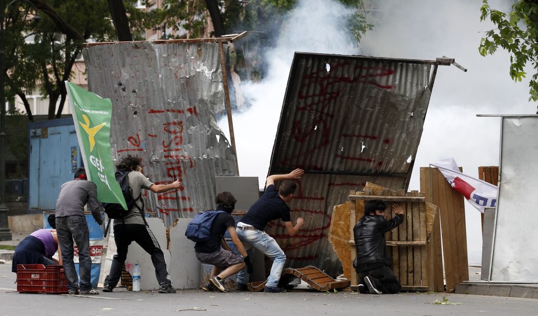 Demonstrators hide behind makeshift shields during clashes with Turkish riot police in Ankara on June 2.
