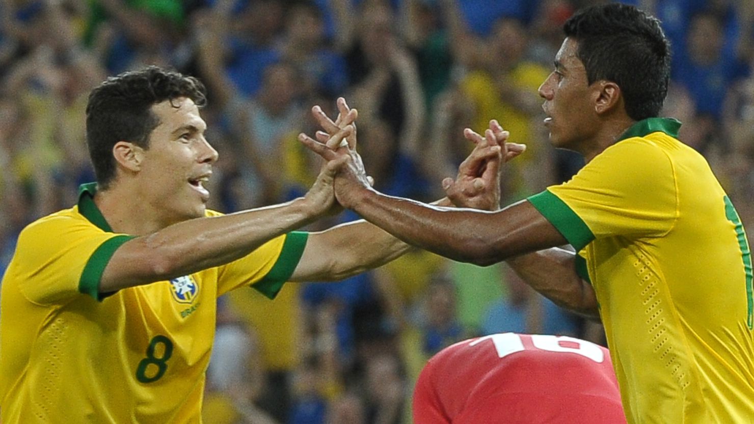 Brazil's Paulinho (R) celebrates with teammate Hermanes after scoring the equalizer against England.
