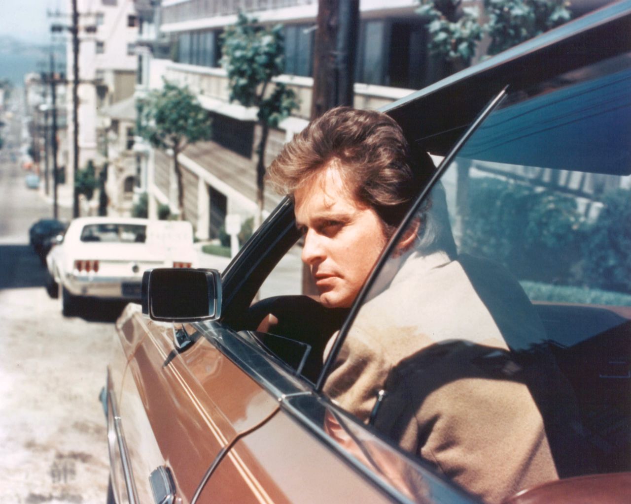 Douglas peers out of the window of a car as Inspector Steve Keller on "Streets of San Francisco."
