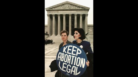 Norma McCorvey (L) formally known as 'Jane Roe,' as she holds a pro-choice sign with former attorney Gloria Allred (R) in front of the US Supreme Court building in Washington, DC, just before attorneys began arguing the 1973 landmark abortion decision which legalized abortion in the US. 