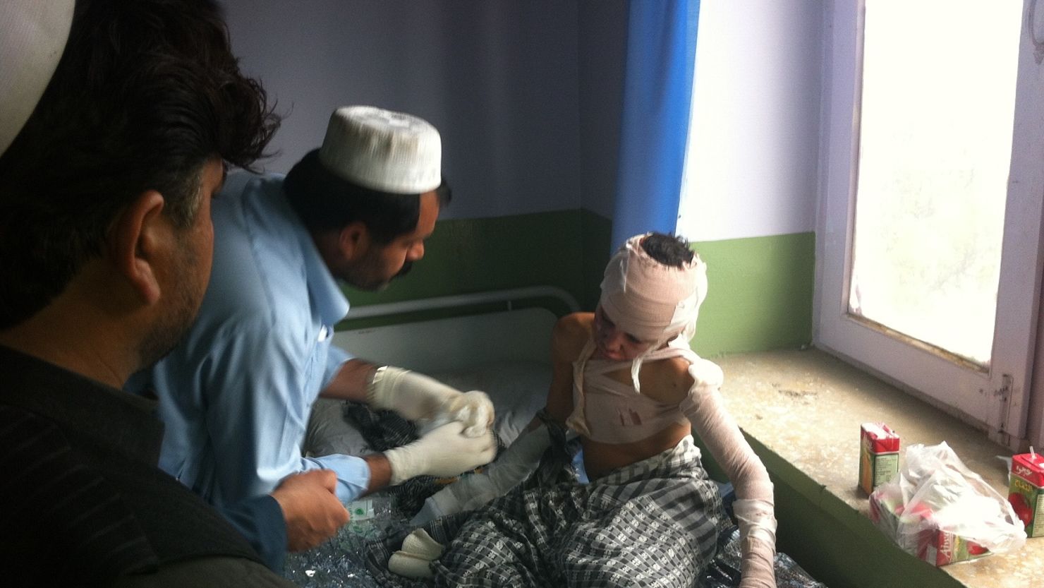 An injured student gets treatment after a suicide bomber blew himself up outside a school.