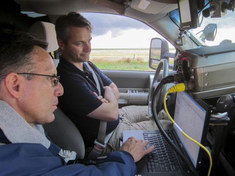 Tim Samaras and Carl Young read data. At a meteorological conference, Samaras encouraged Young to gather data from inside tornadoes for his thesis, and a partnership was born. 