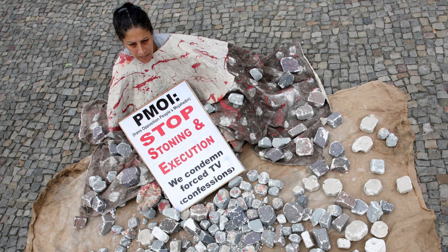File: A woman demonstrates against stoning and execution on August 13, 2010 outside Berlin's landmark the Brandenburg Gate.