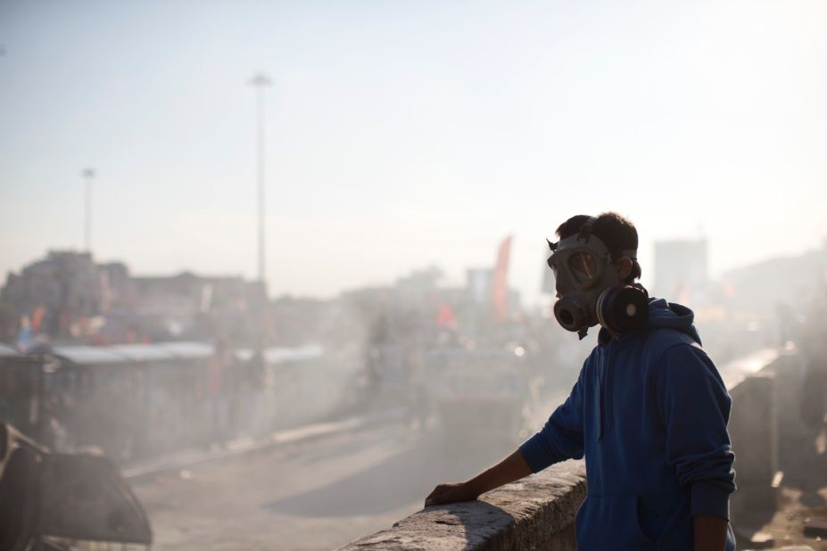 A protester wears a gas mask as smoke from a burned car fills the air at Taksim Square on June 3.