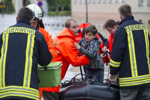 Firefighters and helpers evacuate citizens in the flooded city center in Grimma, Germany. 